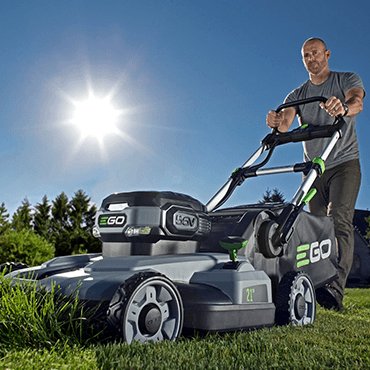 Man mowing tall grass with an EGO lawn mower.